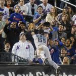 
              Fans watch as Miami Marlins' Eddy Alvarez (65) chases a foul ball hit by New York Mets' James McCann during the fourth inning of a baseball game, Thursday, Sept. 30, 2021, in New York. Alvarez did not make the catch for an out on the play.(AP Photo/Frank Franklin II)
            