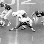 
              FILE - In this Nov. 25, 1971 file photo, Nebraska's Johnny Rodgers (20) avoids Oklahoma defenders as he returns a punt for a touchdown in the first quarter of an NCAA college football game in Norman, Okla. The game, which Nebraska won 35-31, is widely remembered as "The Game of the Century."  (Lincoln Journal Star via AP, File)
            