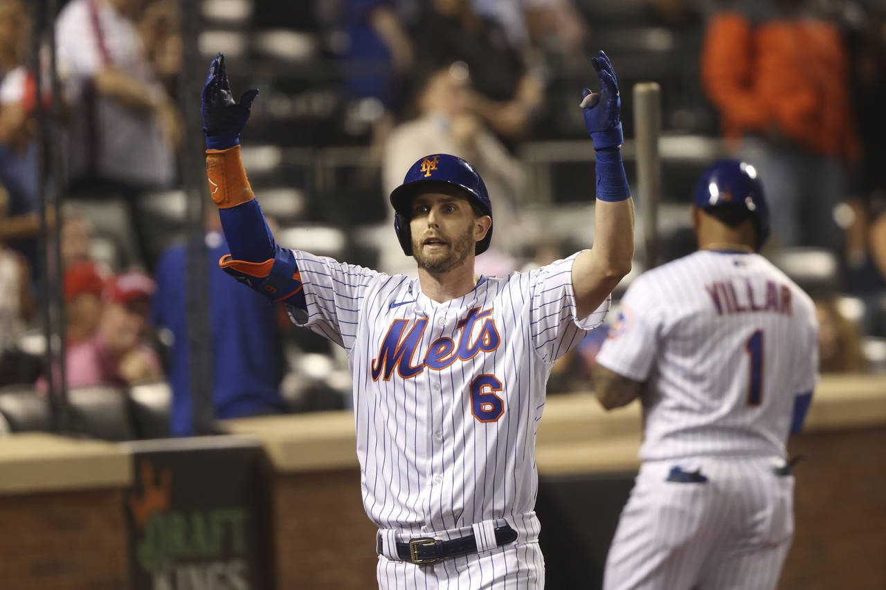 New York Mets' Jeff McNeil celebrates as he returns to the dugout after hitting a home run during t...