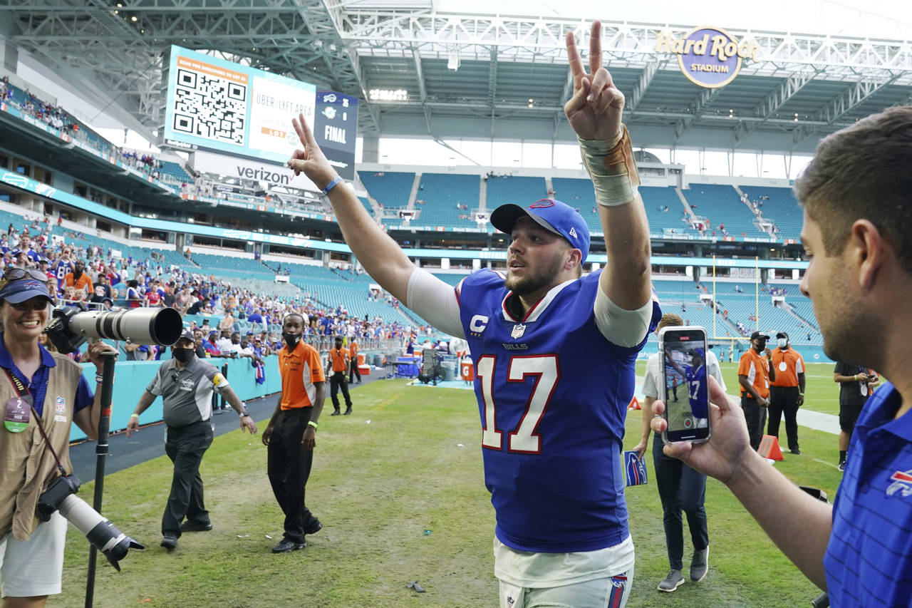 Buffalo Bills quarterback Josh Allen (17) raises his arms at the end of an NFL football game agains...