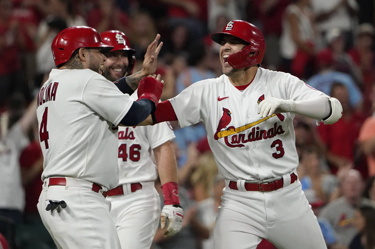 St. Louis Cardinals' Dylan Carlson (3) is congratulated by teammates Yadier Molina (4) and Paul Gol...