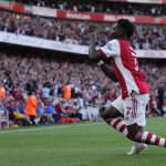 
              Arsenal's Bukayo Saka celebrates after scoring his side's third goal during the English Premier League soccer match between Arsenal and Tottenham Hotspur at the Emirates stadium in London, Sunday, Sept. 26, 2021. (AP Photo/Frank Augstein)
            