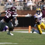 
              LSU wide receiver Trey Palmer (33) runs past Mississippi State lineman Grant Jackson (52) for a yardage gain during the first half of an NCAA college football game, Saturday, Sept. 25, 2021, in Starkville, Miss. (AP Photo/Rogelio V. Solis)
            