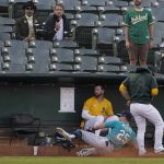 
              Seattle Mariners left fielder Dylan Moore (25) cannot catch a foul ball hit by Oakland Athletics' Matt Olson as he slides into the Athletics bullpen during the first inning of a baseball game in Oakland, Calif., Monday, Sept. 20, 2021. (AP Photo/Jeff Chiu)
            