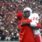 
              FILE - In this Nov. 25, 1971, file photo, Nebraska's Johnny Rodgers (20) hugs an assistant coach on the sideline after his punt return for a touchdown against Oklahoma in the first quarter of  college football game in Norman, Okla., on Thanksgiving Day. The game on Thanksgiving 50 years ago is back in the spotlight as Nebraska and Oklahoma renew their rivalry on Saturday, Sept. 18, 2021. (Lincoln Journal Star via AP, File)
            