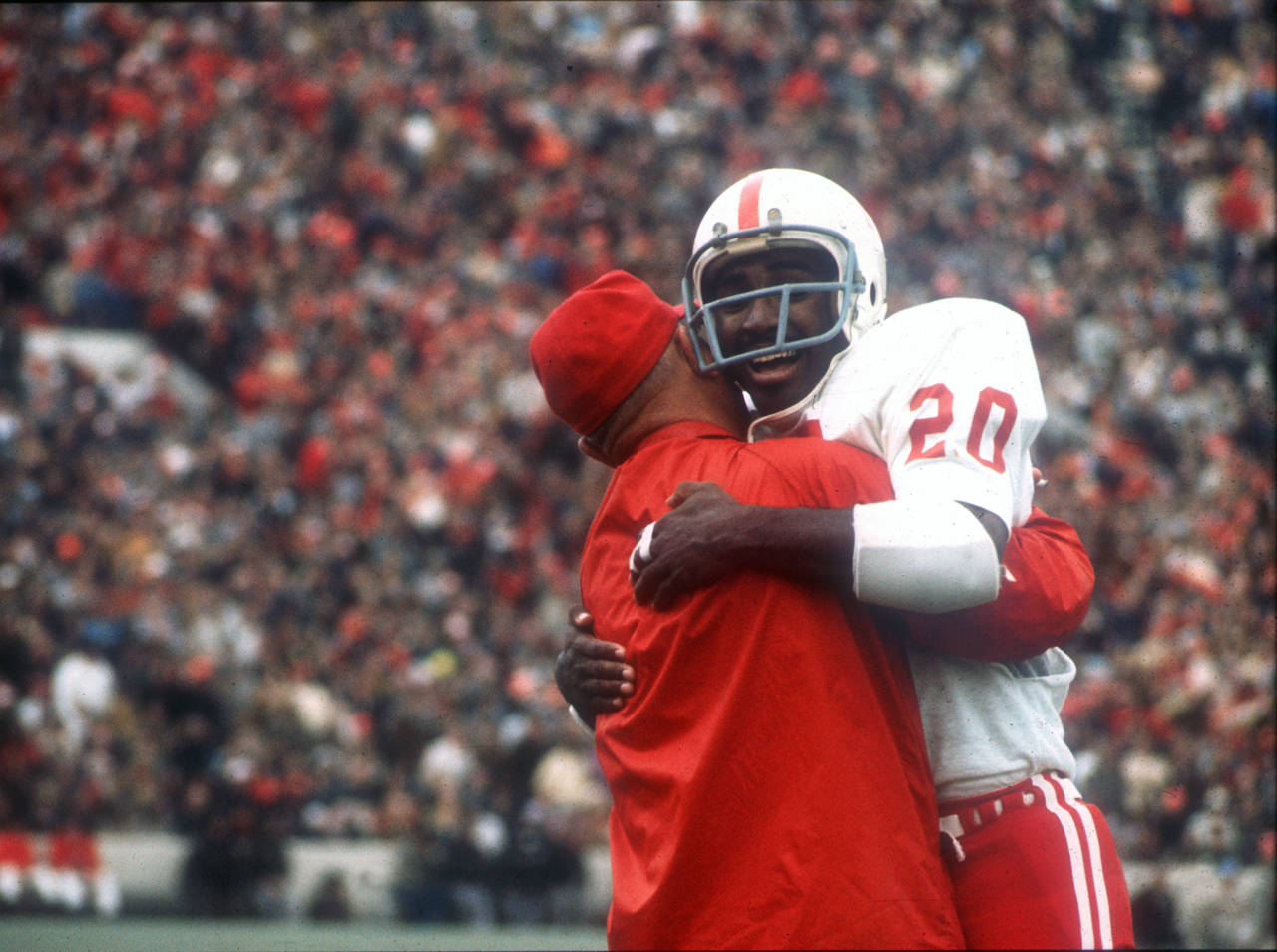 FILE - In this Nov. 25, 1971, file photo, Nebraska's Johnny Rodgers (20) hugs an assistant coach on...