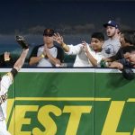 
              San Diego Padres right fielder Wil Myers pulls his glove back over the wall after making the catch for the out on San Francisco Giants' Steven Duggar during the eighth inning of a baseball game Tuesday, Sept. 21, 2021, in San Diego. (AP Photo/Gregory Bull)
            