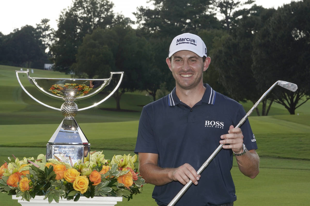 Patrick Cantlay poses with the trophies after winning the Tour Championship golf tournament and the...