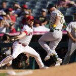 
              Oakland Athletics' Seth Brown, center, safely takes first base as Los Angeles Angels first baseman Jared Walsh, left, fields a throw during the 10th inning of a baseball game Sunday, Sept. 19, 2021, in Anaheim, Calif. (AP Photo/Jae C. Hong)
            