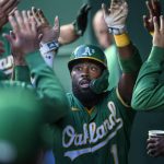 
              Oakland Athletics' Josh Harrison is congratulated after scoring against the Kansas City Royals during the first inning of a baseball game, Tuesday, Sept. 14, 2021 in Kansas City, Mo. (AP Photo/Reed Hoffmann)
            