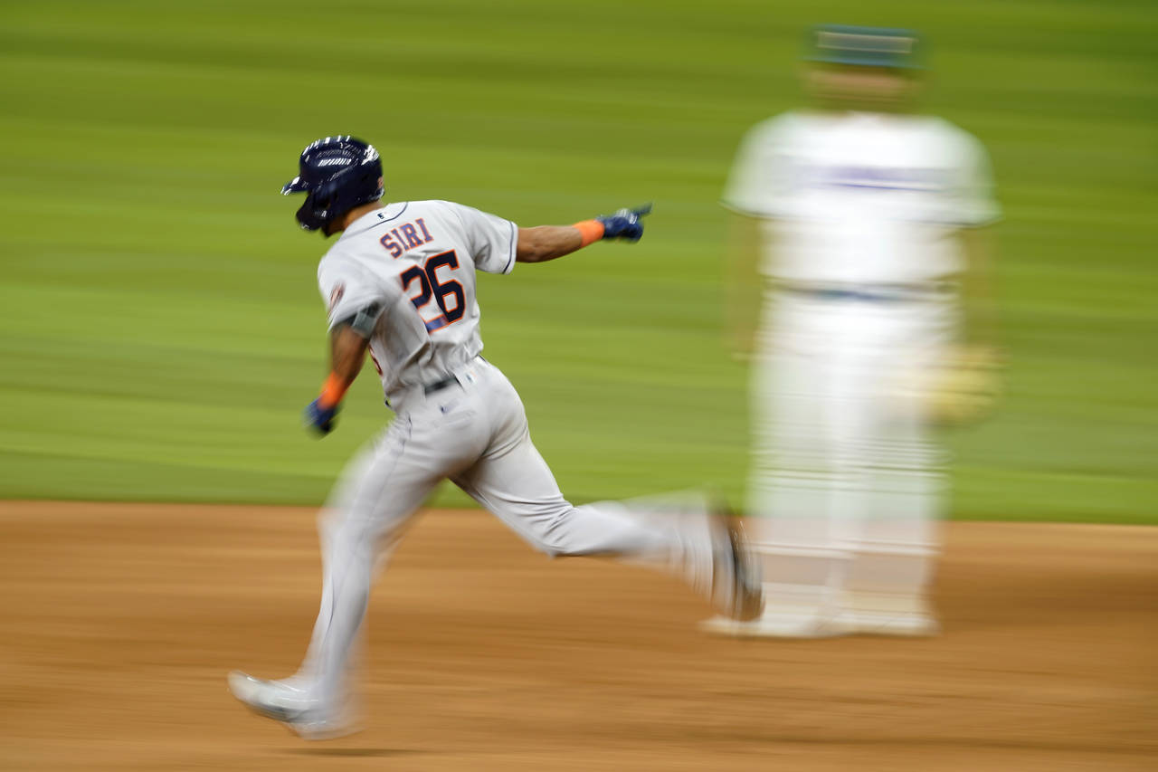 Houston Astros' Jose Siri (26) celebrates his solo home run as he rounds the bases past Texas Range...