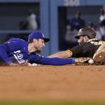 
              San Diego Padres' Eric Hosmer, right, slides in for a double as Los Angeles Dodgers second baseman Trea Turner misses the tag on him during the seventh inning of a baseball game Tuesday, Sept. 28, 2021, in Los Angeles. (AP Photo/Mark J. Terrill)
            