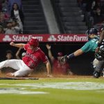 
              Los Angeles Angels' Phil Gosselin, left, scores under the tag of Seattle Mariners catcher Cal Raleigh on a double by Brandon Marsh during the fifth inning of a baseball game Saturday, Sept. 25, 2021, in Anaheim, Calif. (AP Photo/Mark J. Terrill)
            