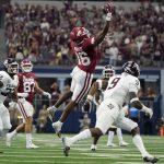 
              Arkansas wide receiver Treylon Burks (16) makes a one-handed catch between Texas A&M linebacker Andre White Jr. (32) and defensive back Leon O'Neal Jr. (9) in the first half of an NCAA college football game in Arlington, Texas, Saturday, Sept. 25, 2021. (AP Photo/Tony Gutierrez)
            