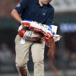 
              A member of the Atlanta Braves grounds crew works to dry the infield during the team's baseball game against the Colorado Rockies on Wednesday, Sept. 15, 2021, in Atlanta. (AP Photo/John Bazemore)
            