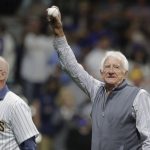 
              Broadcaster Bob Uecker, right, waves to the crowd after throwing out the ceremonial first pitch before a baseball game between the Milwaukee Brewers and the New York Mets Saturday, Sept. 25, 2021, in Milwaukee. (AP Photo/Aaron Gash)
            