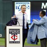 
              Former Minnesota Twins player Justin Morneau, left, sheds his jacket as former Twins great and Hall of Famer Rod Carew presents the new jacket after Morneau was inducted into the Twins' Hall of Fame prior to a baseball game against the Toronto Blue Jays, Saturday, Sept. 25, 2021, in Minneapolis. (AP Photo/Jim Mone)
            