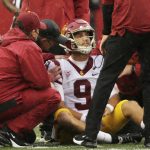 
              Southern California team staff helps quarterback Kedon Slovis (9) after Slovis was shaken up on a play during the first half of an NCAA college football game against Washington State, Saturday, Sept. 18, 2021, in Pullman, Wash. (AP Photo/Young Kwak)
            