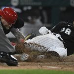 
              Chicago White Sox's Leury Garcia (28) slides into home plate while being tagged out by Cincinnati Reds catcher Tucker Barnhart right, while trying for an inside the park home run during the fourth inning of a baseball game Tuesday, Sept. 28, 2021, in Chicago. (AP Photo/Paul Beaty)
            