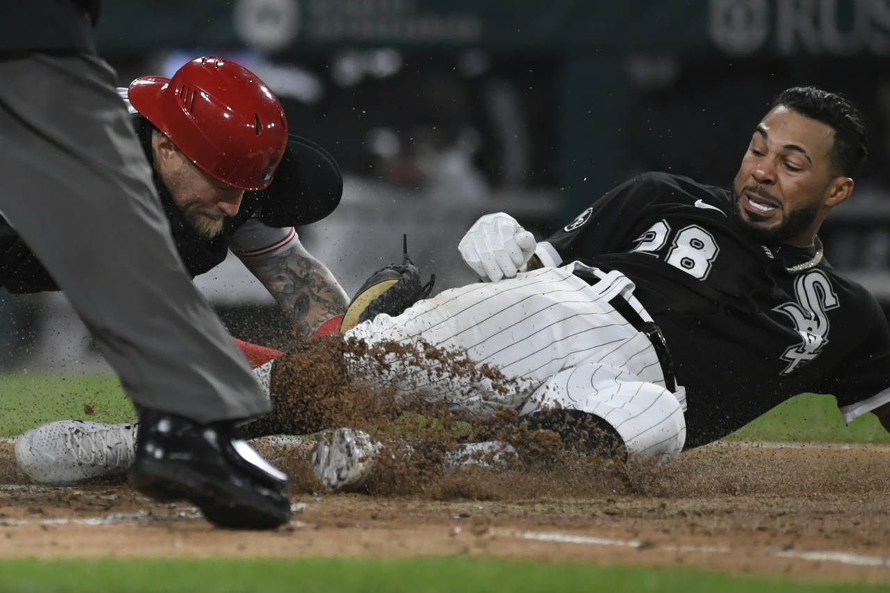 Chicago White Sox's Leury Garcia (28) slides into home plate while being tagged out by Cincinnati R...