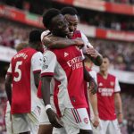 
              Arsenal's Bukayo Saka, center, celebrates after scoring his side's third goal during the English Premier League soccer match between Arsenal and Tottenham Hotspur at the Emirates stadium in London, Sunday, Sept. 26, 2021. (AP Photo/Frank Augstein)
            