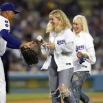 
              Los Angeles Dodgers manager Dave Roberts, left, gives a baseball back to former manager Tommy Lasorda's granddaughter Emily Tess, center, after she threw the game's ceremonial first pitch before a baseball game against the Arizona Diamondbacks Monday, Sept. 13, 2021, in Los Angeles. (AP Photo/Marcio Jose Sanchez)
            