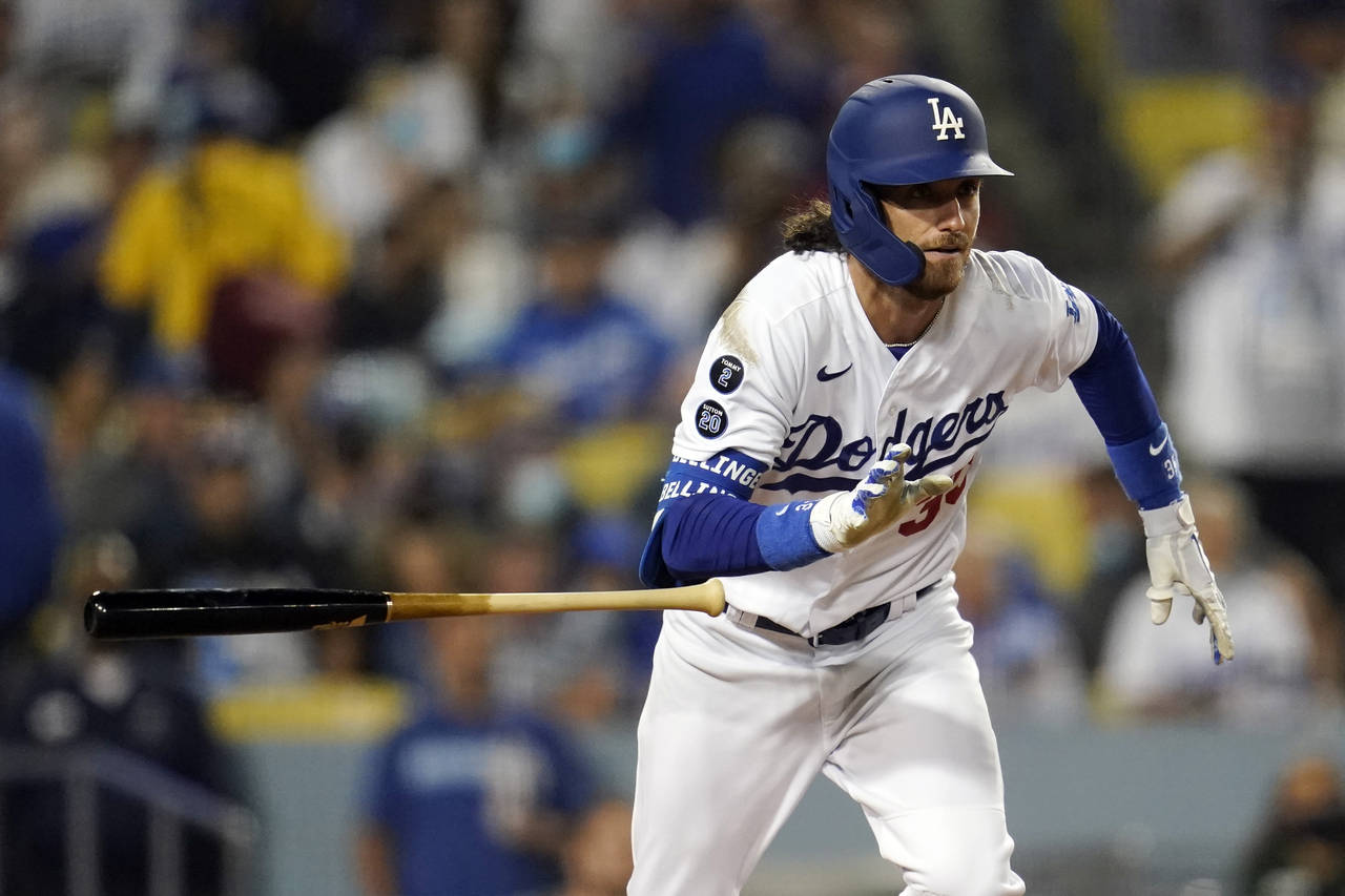 Los Angeles Dodgers' Cody Bellinger drops his bat as he doubles during the seventh inning of a base...