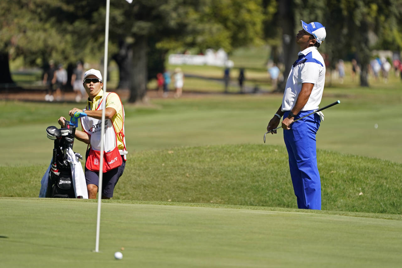 Hideki Matsuyama, right,of Japan, reacts after missing a hit for birdie on the sixth green of the S...