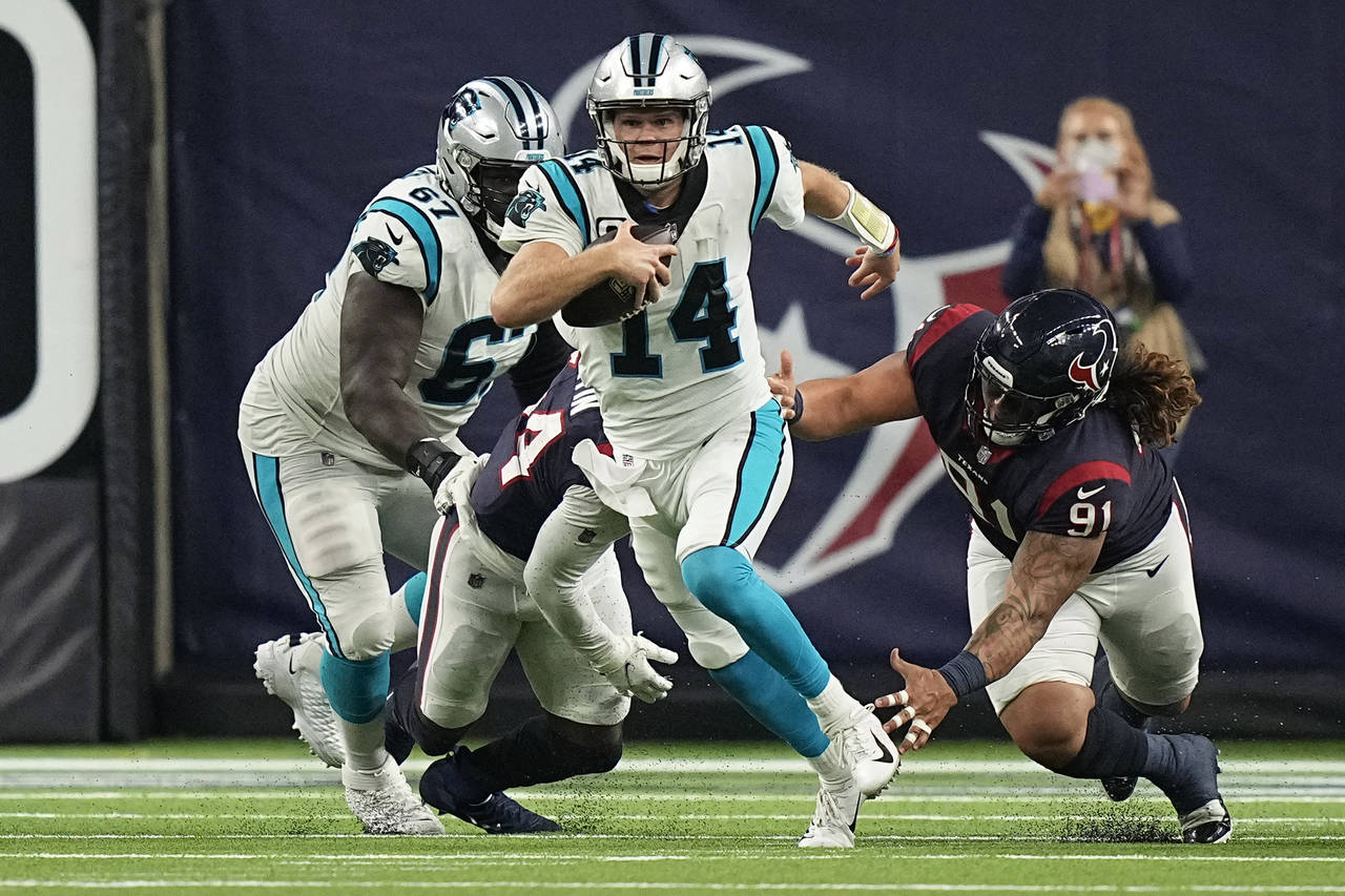 Carolina Panthers quarterback Sam Darnold (14) breaks away from Houston Texans defensive tackle Roy...