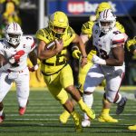 
              Oregon running back Travis Dye (26) runs past Stony Brook defensive lineman Casey Williams (2) and Stony Brook defensive lineman Dakar Edwards (93) during the first quarter of an NCAA college football game Saturday, Sept. 18, 2021, in Eugene, Ore. (AP Photo/Andy Nelson)
            