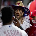 
              Philadelphia Phillies' Bryce Harper, center, and Jean Segura celebrate in the dugout after Harper's home run against Colorado Rockies pitcher Tyler Kinley during the seventh inning of a baseball game, Saturday, Sept. 11, 2021, in Philadelphia. (AP Photo/Matt Slocum)
            