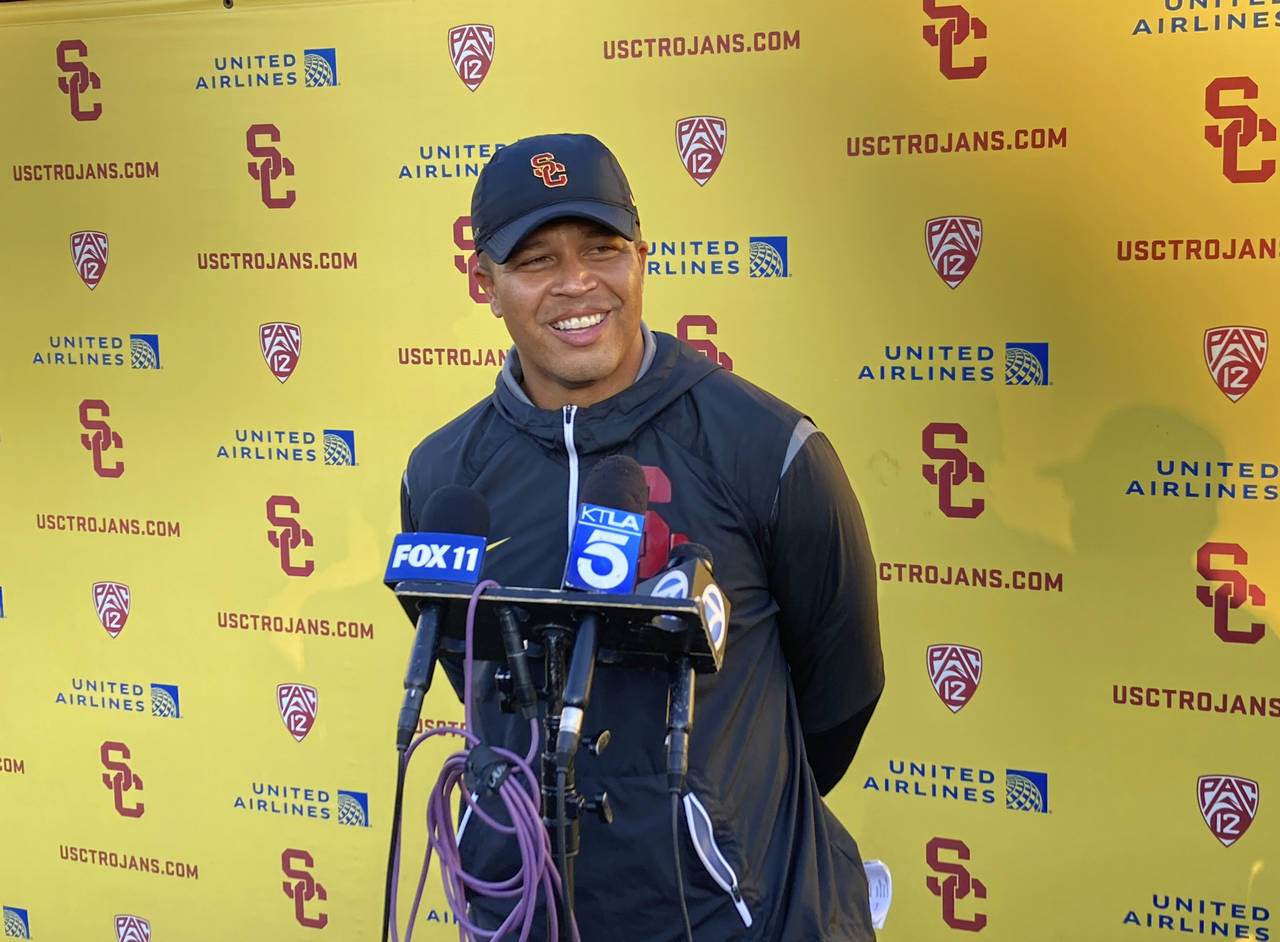 Southern California interim head football coach Donte Williams smiles while answering questions aft...