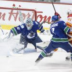 
              Vancouver Canucks goalie Michael DiPietro (65) stops Calgary Flames' Walker Duehr (61) as Canucks' Jack Rathbone (3) defends during the first period of a preseason NHL hockey game in Abbotsford, British Columbia, Monday, Sept. 27, 2021. ( Darryl Dyck/The Canadian Press via AP)
            