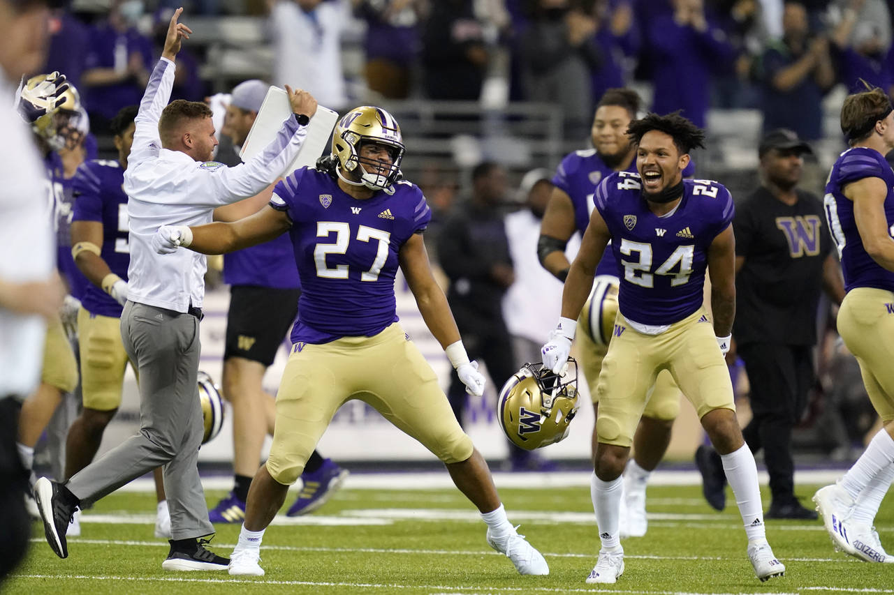 Washington players and coaches celebrate beating California in an NCAA college football game Saturd...