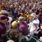 
              Minnesota mascot Goldy the Golden Gopher, front center, is helped up after fans collapsed the fence around the field and trapped the mascot after an NCAA college football game against Colorado, Saturday, Sept. 18, 2021, in Boulder, Colo. Minnesota won 30-0. (AP Photo/David Zalubowski)
            