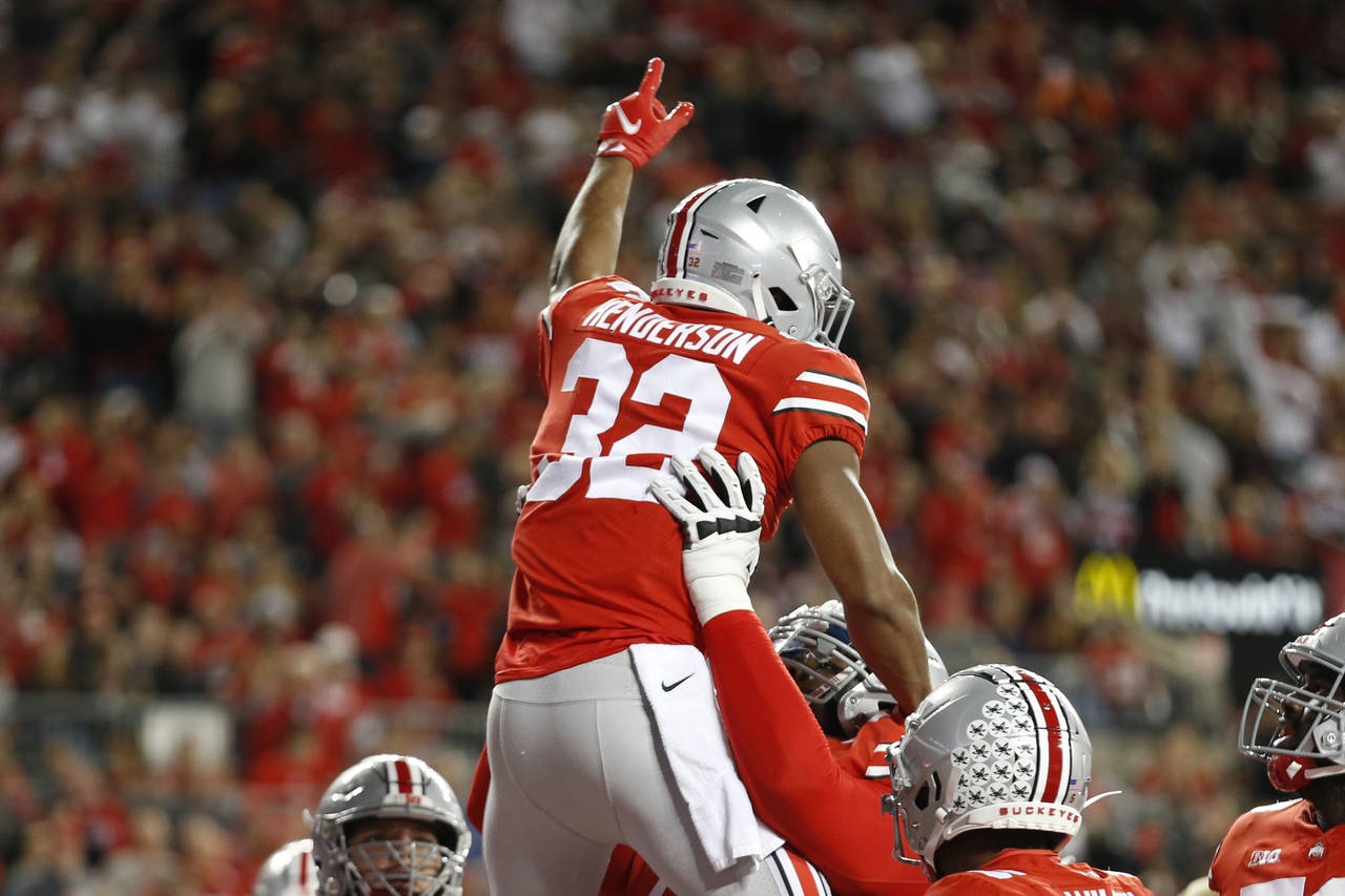 Ohio State running back TreVeyon Henderson, top, celebrates his touchdown against Akron during the ...