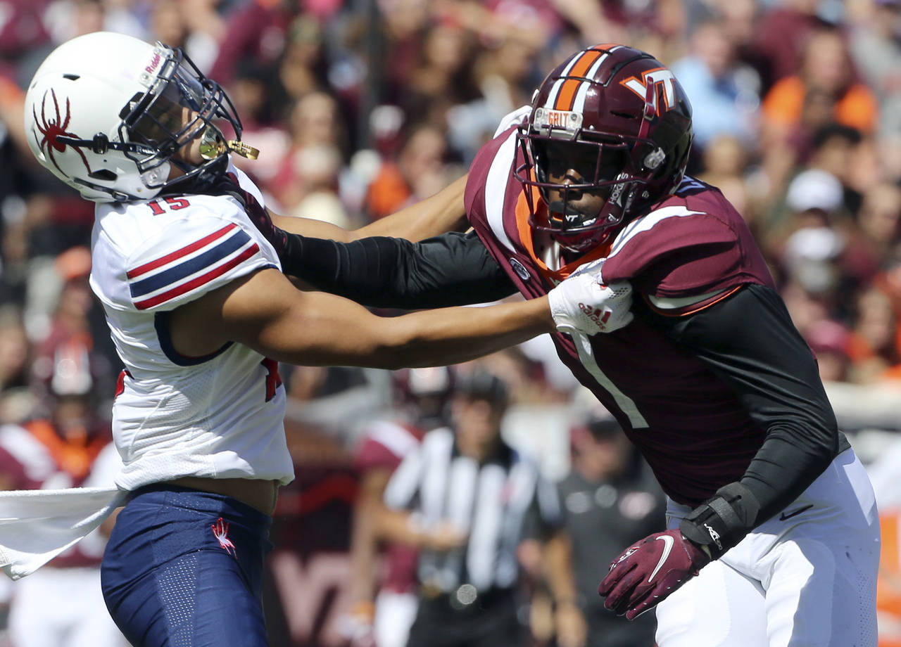 Richmond's Isaac Brown (15) battles for position with Virginia Tech defensive back Chamarri Conner ...