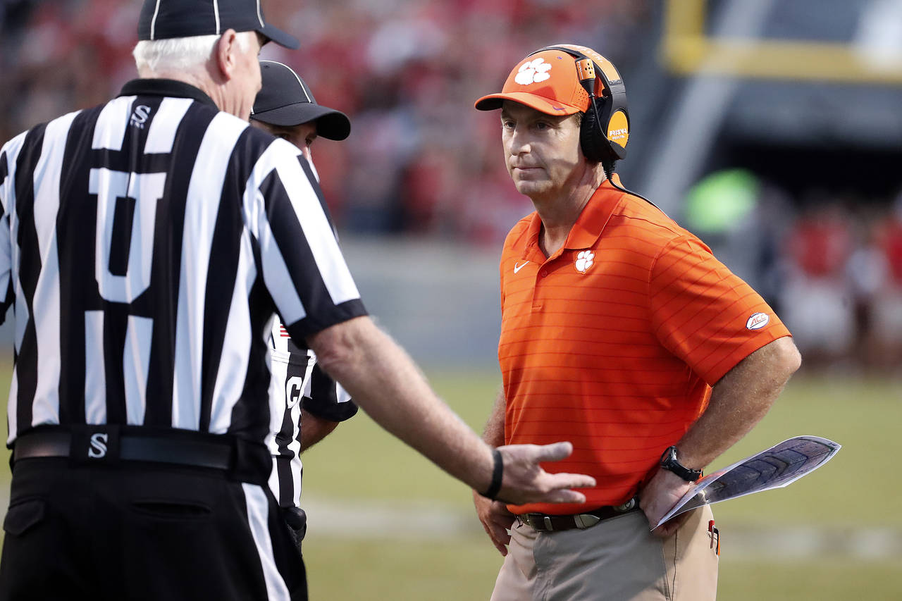 Clemson head coach Dabo Swinney, right, speaks with officials during the second half of an NCAA col...