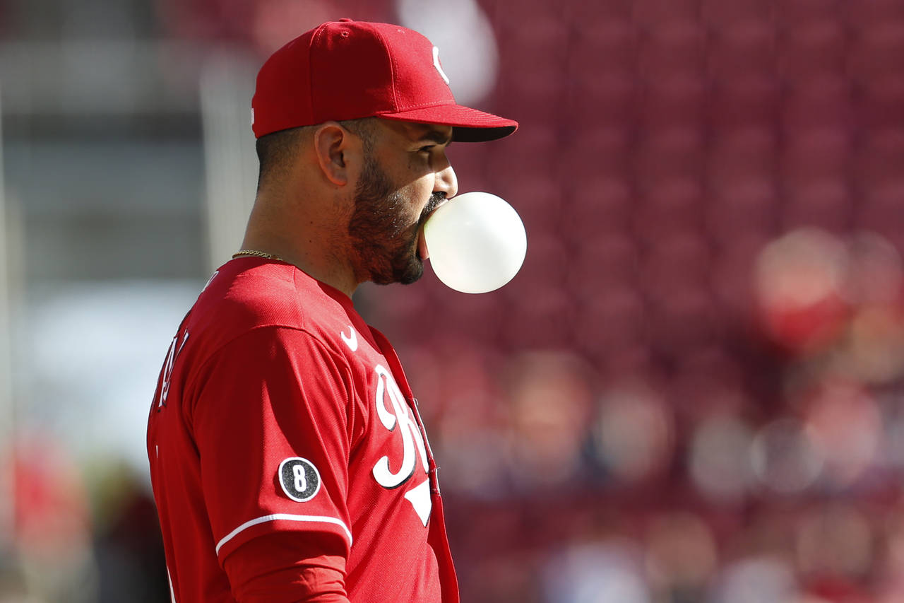 Cincinnati Reds' Eugenio Suarez blows a bubble while waiting for the next pitch against and Washing...