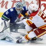 
              Calgary Flames' Justin Kirkland (52) crashes into Vancouver Canucks goalie Michael DiPietro (65) during the third period of a preseason NHL hockey game in Abbotsford, British Columbia, Monday, Sept. 27, 2021. (Darryl Dyck/The Canadian Press via AP)
            