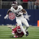 
              Texas A&M running back Isaiah Spiller (28) escapes a tackle attempt by Arkansas linebacker Grant Morgan, rear, in the first half of an NCAA college football game in Arlington, Texas, Saturday, Sept. 25, 2021. (AP Photo/Tony Gutierrez)
            
