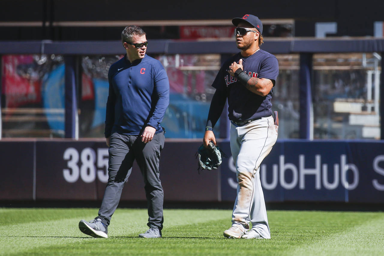 Cleveland Indians' Harold Ramirez, right, walks off the field after crashing into the wall while at...
