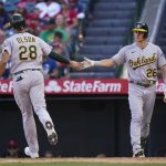 
              Oakland Athletics' Matt Olson, left, is congratulated by Matt Chapman after he scored on a sacrifice fly by Jed Lowrie during the 10th inning of a baseball game against the Los Angeles Angels, Sunday, Sept. 19, 2021, in Anaheim, Calif. (AP Photo/Jae C. Hong)
            