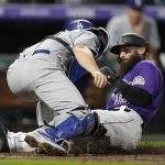 
              Los Angeles Dodgers catcher Will Smith, front, applies a late tag as Colorado Rockies' Charlie Blackmon scores on a double hit by C.J. Cron in the seventh inning of a baseball game Wednesday, Sept. 22, 2021, in Denver. (AP Photo/David Zalubowski)
            