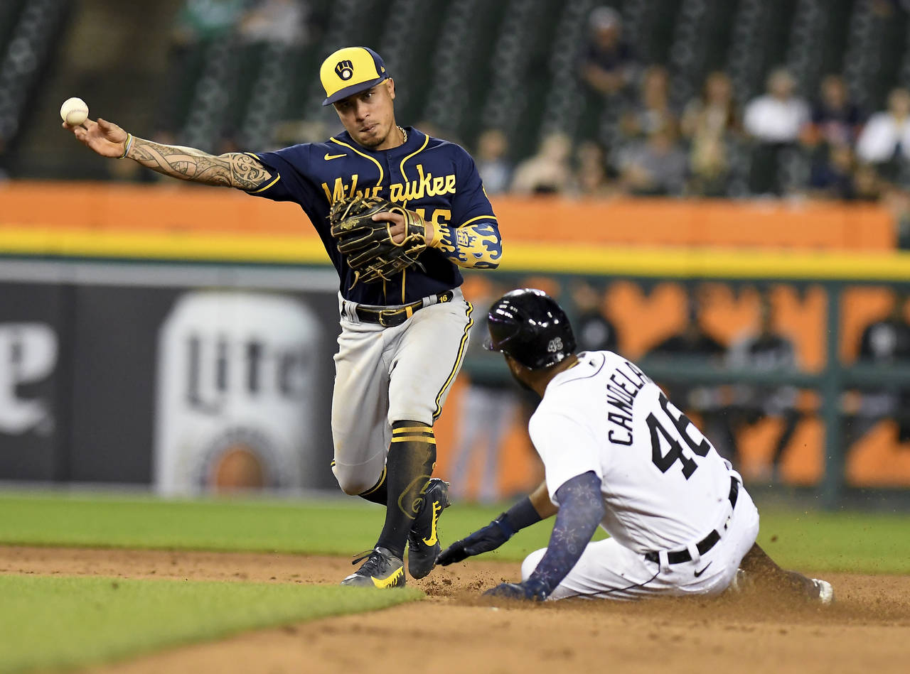 Milwaukee Brewers second baseman Kelton Wong throws to first after forcing out Detroit Tigers' Jeim...