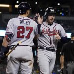
              Atlanta Braves' Freddie Freeman high fives Austin Riley (27) after scoring on a double hit by Ozzie Albies during the fifth inning of a baseball game against the Arizona Diamondbacks, Monday, Sept. 20, 2021, in Phoenix. (AP Photo/Matt York)
            