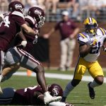 
              LSU running back Corey Kiner (21) turns the corner for a short gain as Mississippi State players pursue during the first half of an NCAA college football game, Saturday, Sept. 25, 2021, in Starkville, Miss. (AP Photo/Rogelio V. Solis)
            
