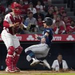 
              Seattle Mariners' Dylan Moore, right, scores on a single by Ty France as Los Angeles Angels catcher Max Stassi stands at the plate during the third inning of a baseball game Friday, Sept. 24, 2021, in Anaheim, Calif. (AP Photo/Mark J. Terrill)
            