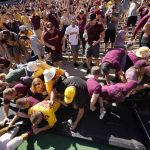 
              Minnesota fans collapse the fence around the field while congratulating players after the second half of an NCAA college football game against Colorado Saturday, Sept. 18, 2021, in Boulder, Colo. Minnesota won 30-0. (AP Photo/David Zalubowski)
            