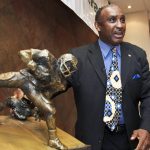 
              FILE - In this Tuesday, March 27, 2012, file photo, a new award to honor college football's top return specialist is announced by 1972 Nebraska Heisman Trophy winner Johnny Rodgers at a news conference in Omaha, Neb. The Johnny "The Jet" Rodgers Award is named for Rodgers, who is widely regarded as one of the top punt and kick returners in college football history. Rodgers’ electrifying 72-yard punt return for a touchdown was the signature play of a rare game that lived up to “Game of the Century” billing, helping No. 1 Nebraska defeat No. 2 Oklahoma 35-31 in the 1971 classic. Fifty years later, Rodgers still gets asked about the play. (AP Photo/Nati Harnik, File)
            
